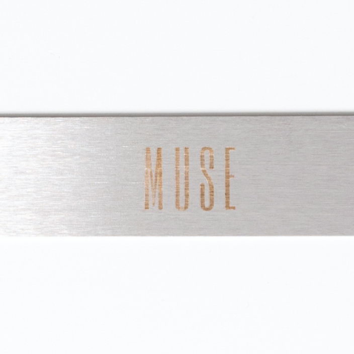 A straight metal nail file with 'MUSE' inscribed on the side.